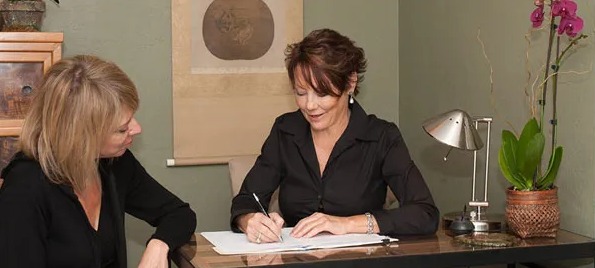 Dr. Kimberly Burke reviewing a plan with a patient at her desk